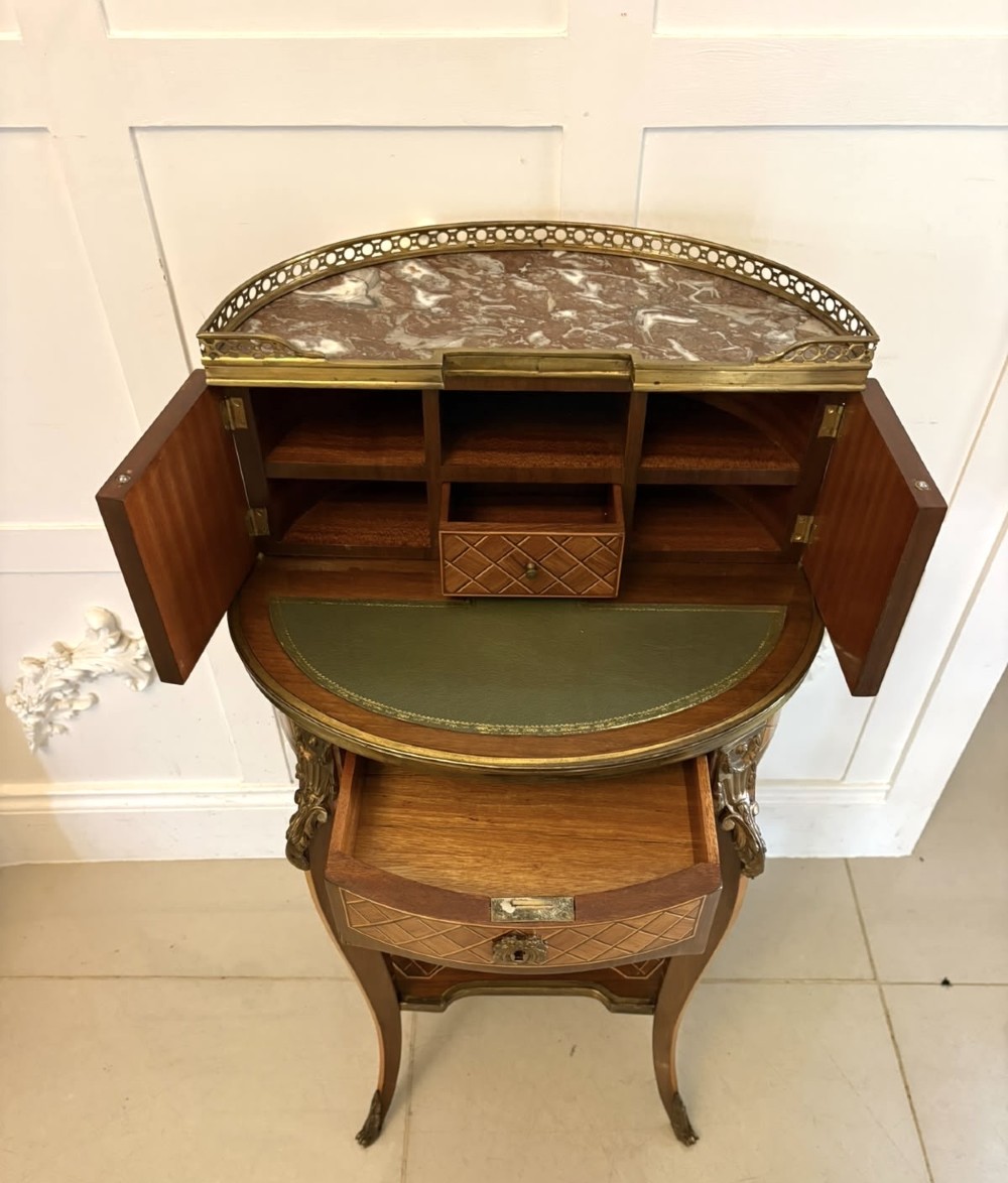 A French kingwood parquetry bonheur du jour writing desk featuring a green leather inset, marble top gallery, and gilt-bronze mounts on slender cabriole legs. View X