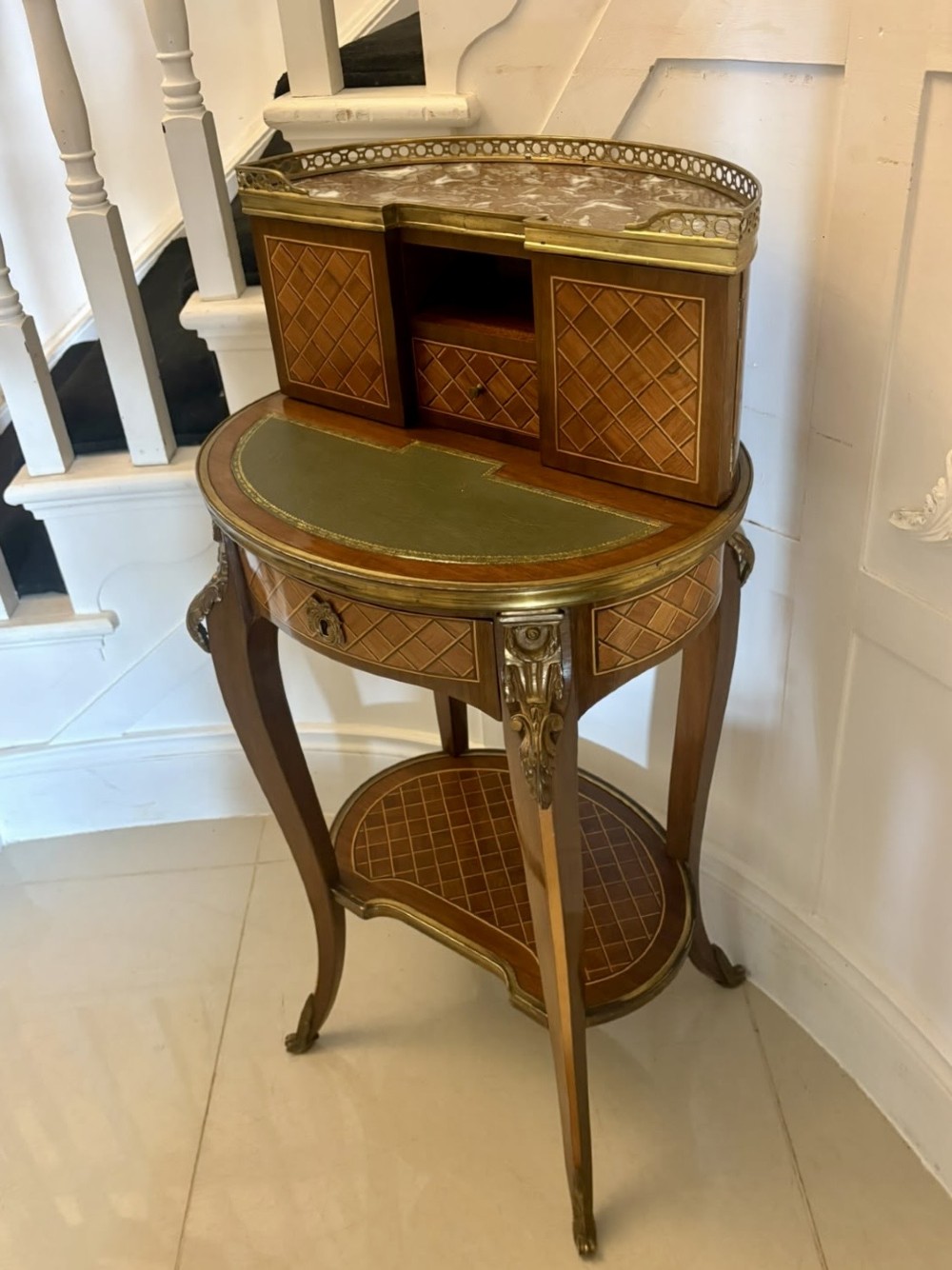 A French kingwood parquetry bonheur du jour writing desk featuring a green leather inset, marble top gallery, and gilt-bronze mounts on slender cabriole legs. View XIV