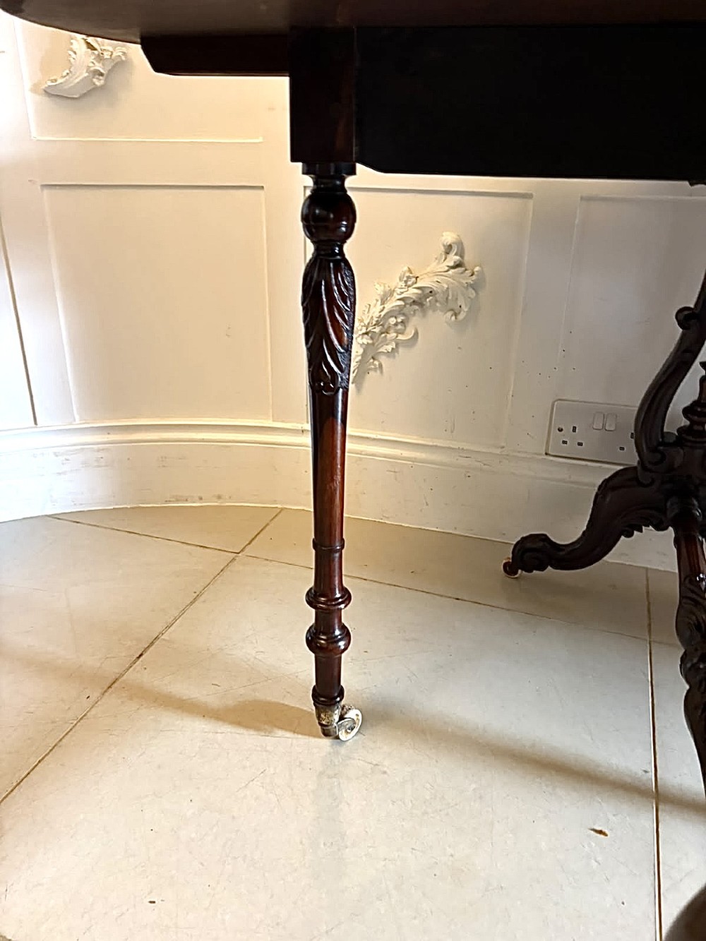 An antique Victorian rosewood Sutherland table with drop leaves, carved legs, and brass castors. View III