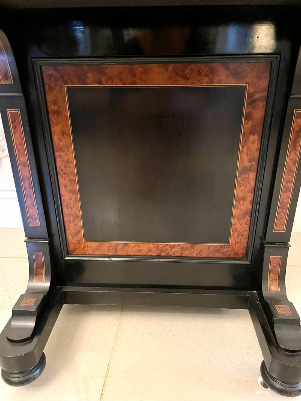 A Victorian ebonised davenport desk featuring walnut crossbanding, a sloped green leather writing surface, side drawers, and a top brass gallery rail. View V