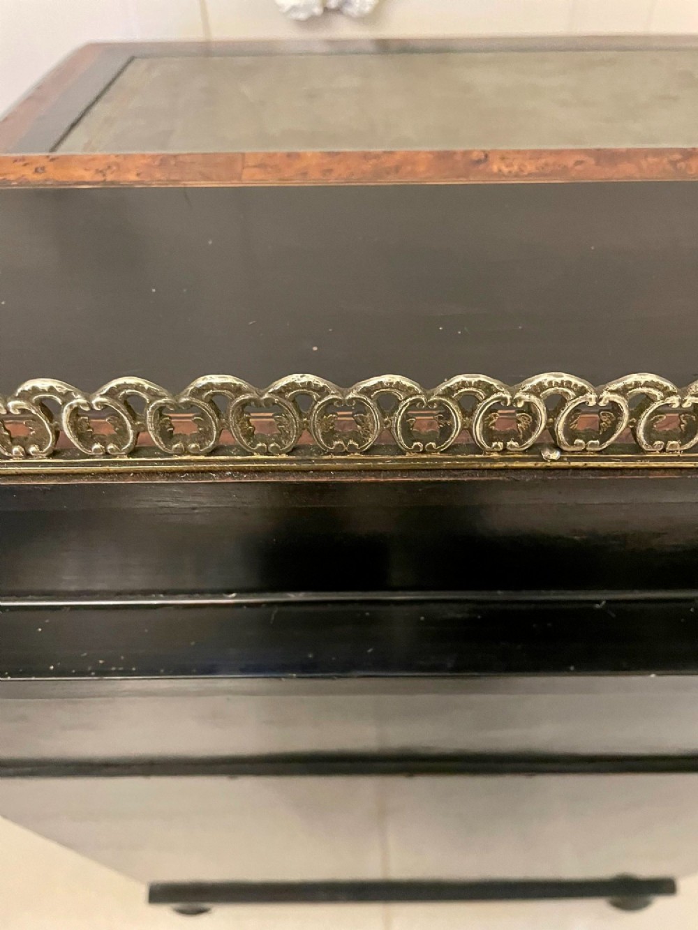 A Victorian ebonised davenport desk featuring walnut crossbanding, a sloped green leather writing surface, side drawers, and a top brass gallery rail. View XIV