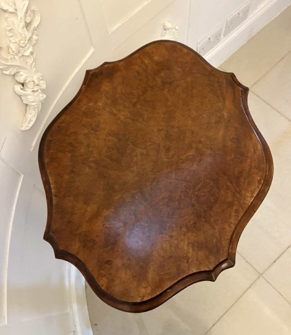 An antique Victorian burr walnut side table featuring a shaped scalloped top, a spiral carved pedestal column, and three carved cabriole legs. View IV