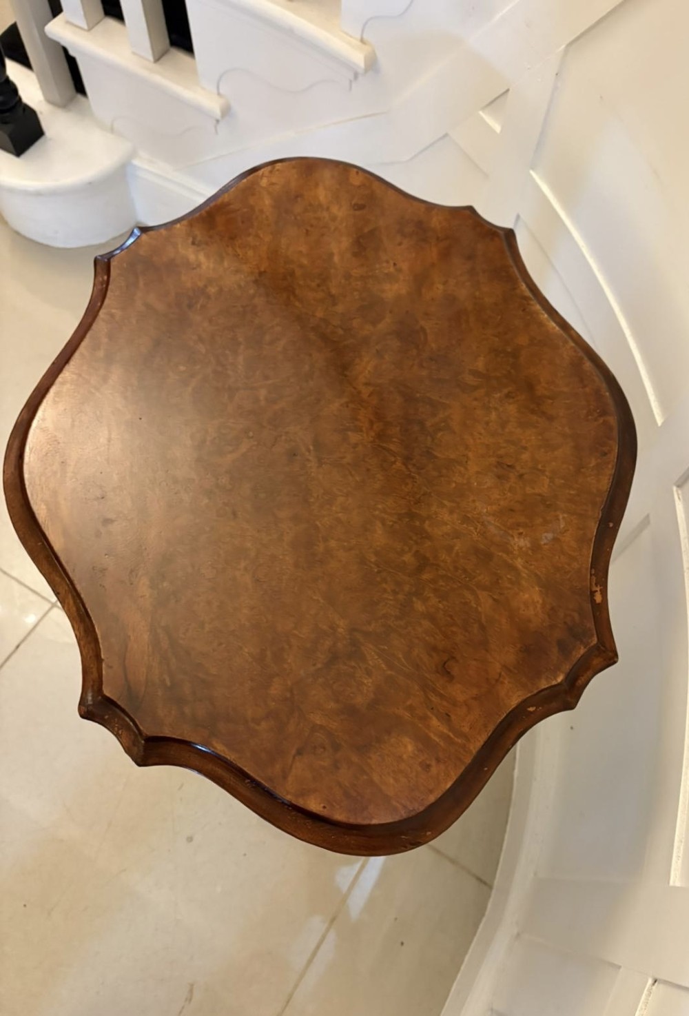 An antique Victorian burr walnut side table featuring a shaped scalloped top, a spiral carved pedestal column, and three carved cabriole legs. View V