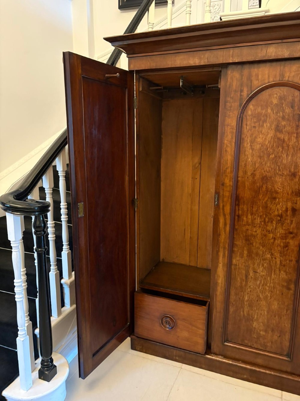 A Victorian three-door wardrobe crafted from figured mahogany with arched door panels, carved top corbels, and a wide moulded cornice. View VIII