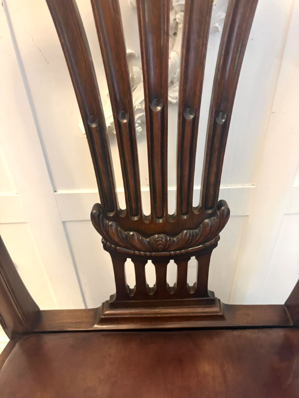 A set of eight Victorian mahogany Hepplewhite style dining chairs with carved shield backs and tan leather seats. View VI