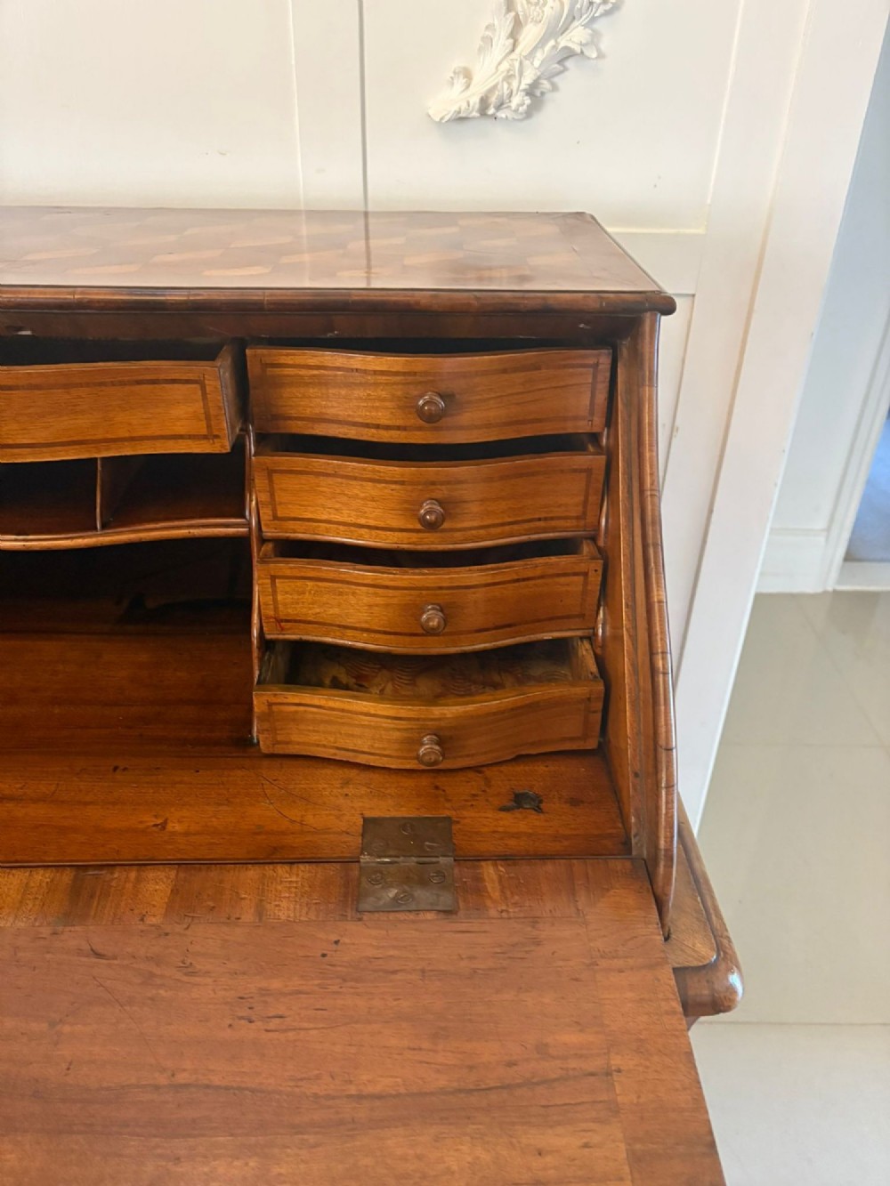 An 18th-century French walnut bureau featuring geometric parquetry inlay, a sloped fall front, a bombee body with two drawers, and brass mounts. View VII