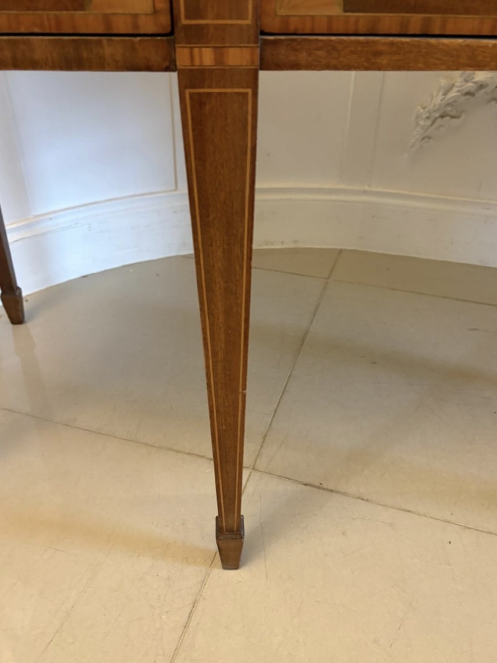 An Edwardian mahogany sideboard featuring satinwood crossbanded inlay, central drawers, flanking curved cupboards, brass ring handles, and square tapered legs. View V