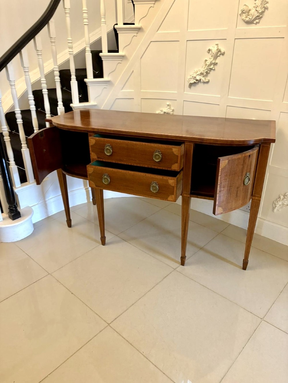 An Edwardian mahogany sideboard featuring satinwood crossbanded inlay, central drawers, flanking curved cupboards, brass ring handles, and square tapered legs. View IX