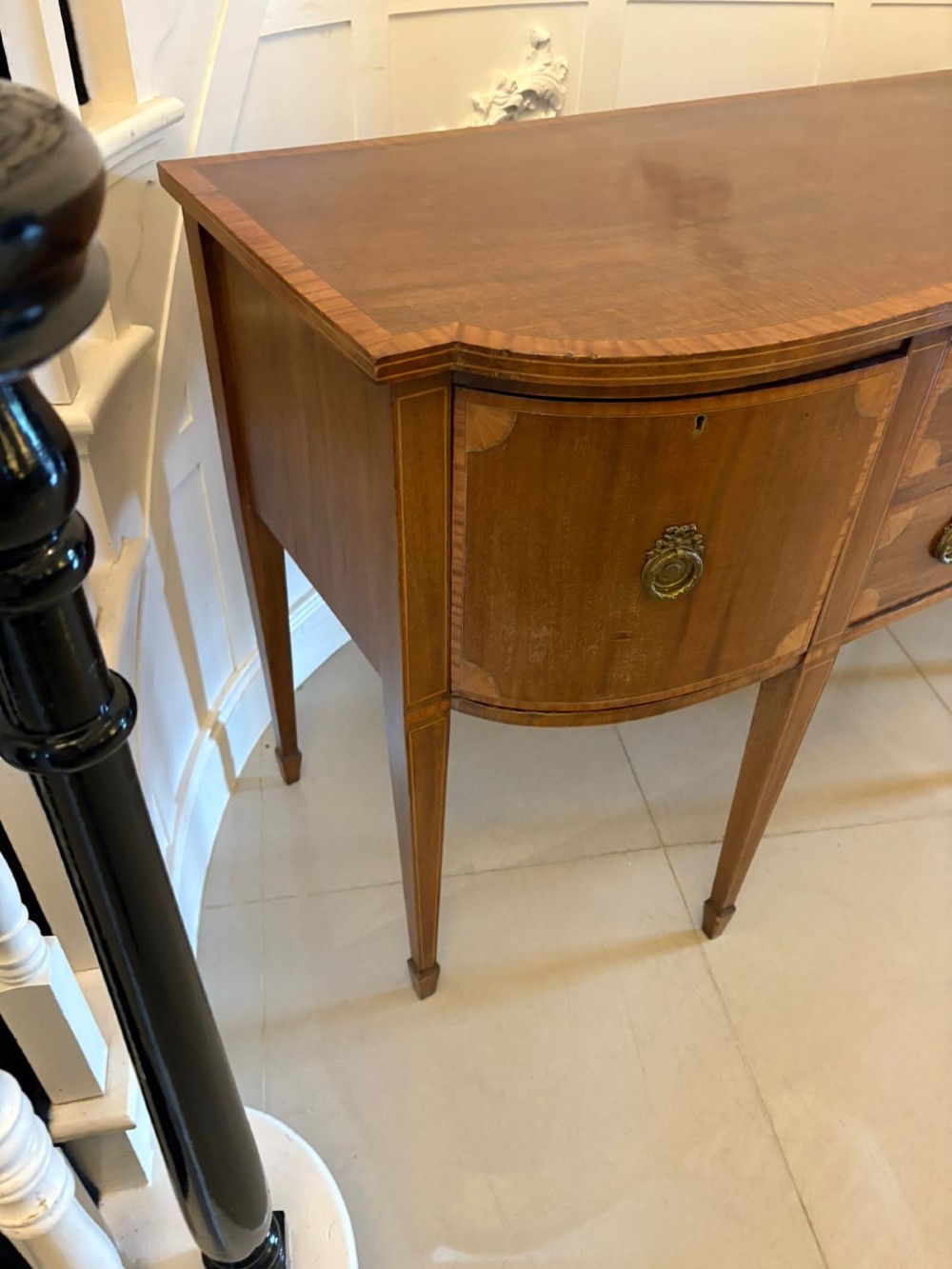 An Edwardian mahogany sideboard featuring satinwood crossbanded inlay, central drawers, flanking curved cupboards, brass ring handles, and square tapered legs. View XIII