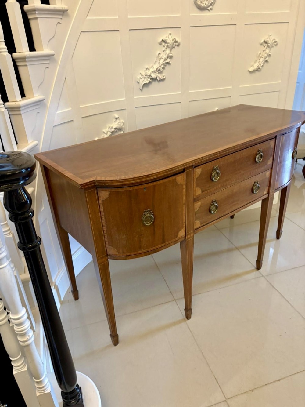 An Edwardian mahogany sideboard featuring satinwood crossbanded inlay, central drawers, flanking curved cupboards, brass ring handles, and square tapered legs. View XIV
