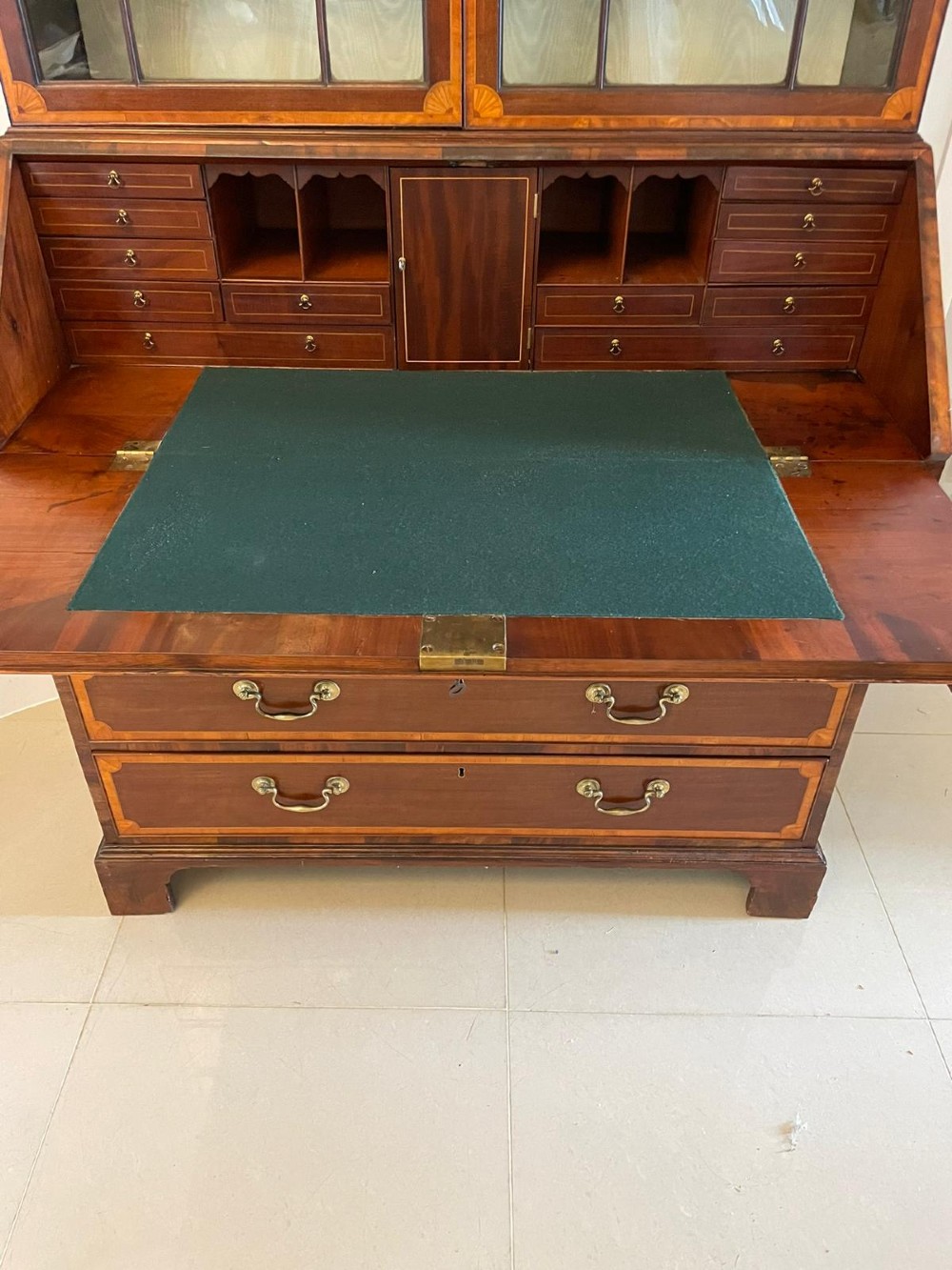 An 18th-century George III mahogany bureau bookcase featuring an upper astragal glazed cabinet above a slanted writing desk with four inlaid drawers and brass handles. View IV