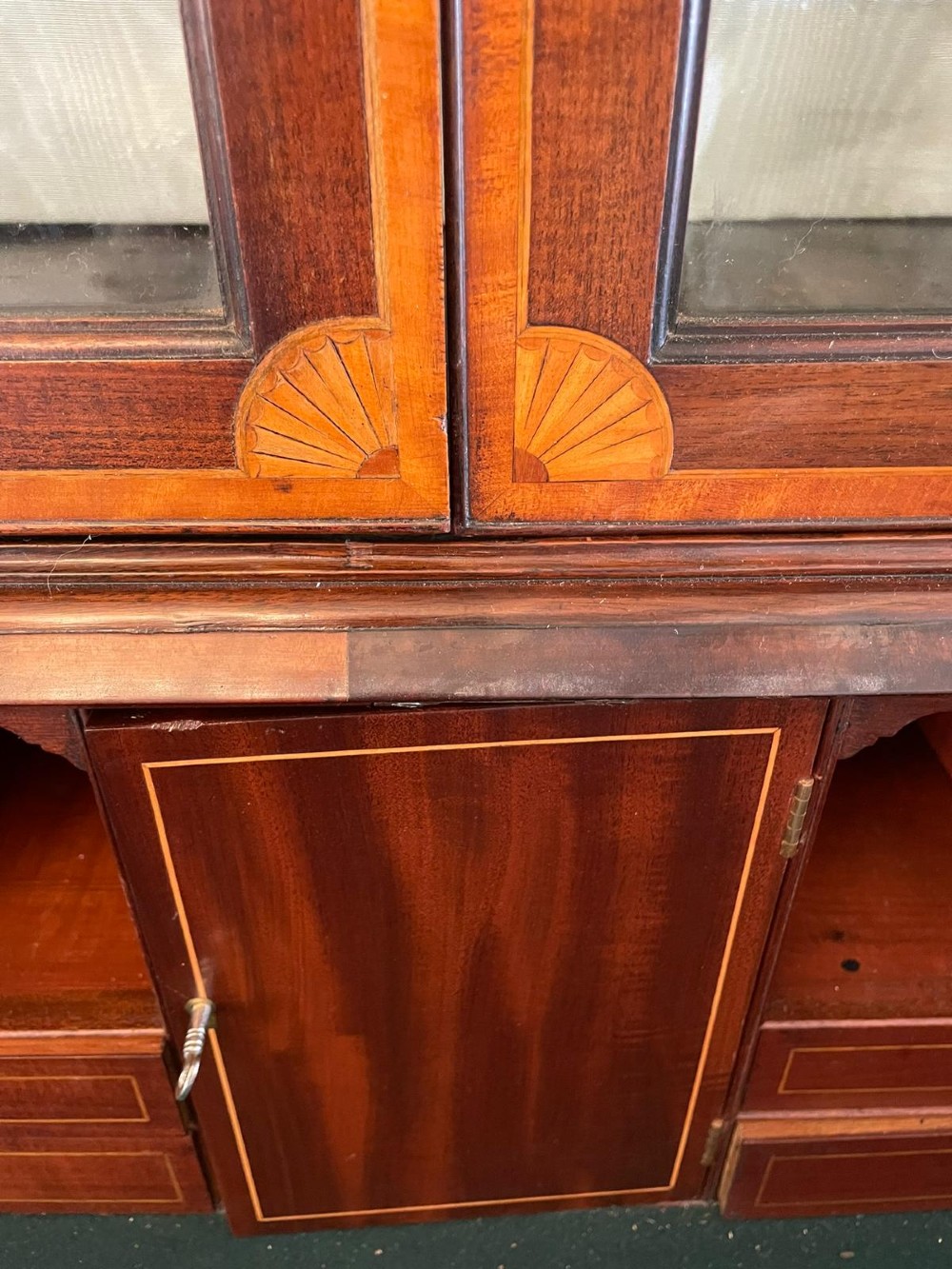 An 18th-century George III mahogany bureau bookcase featuring an upper astragal glazed cabinet above a slanted writing desk with four inlaid drawers and brass handles. View V