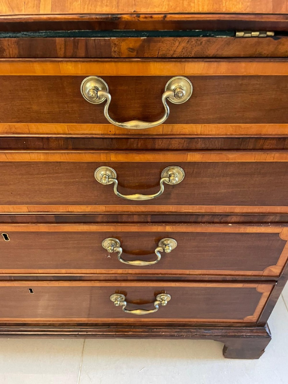 An 18th-century George III mahogany bureau bookcase featuring an upper astragal glazed cabinet above a slanted writing desk with four inlaid drawers and brass handles. View VII