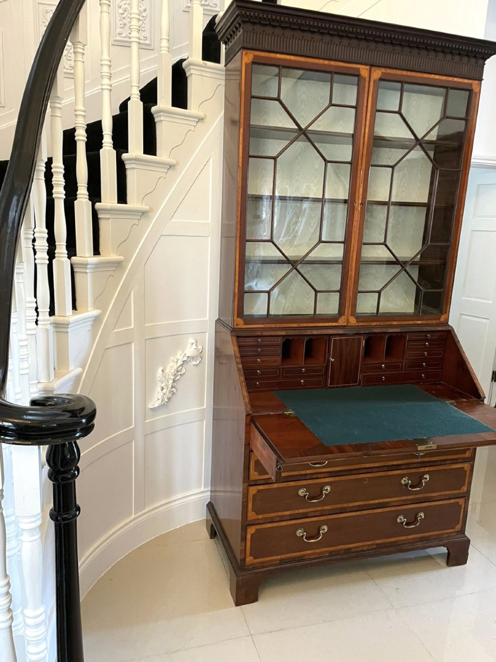 An 18th-century George III mahogany bureau bookcase featuring an upper astragal glazed cabinet above a slanted writing desk with four inlaid drawers and brass handles. View XII