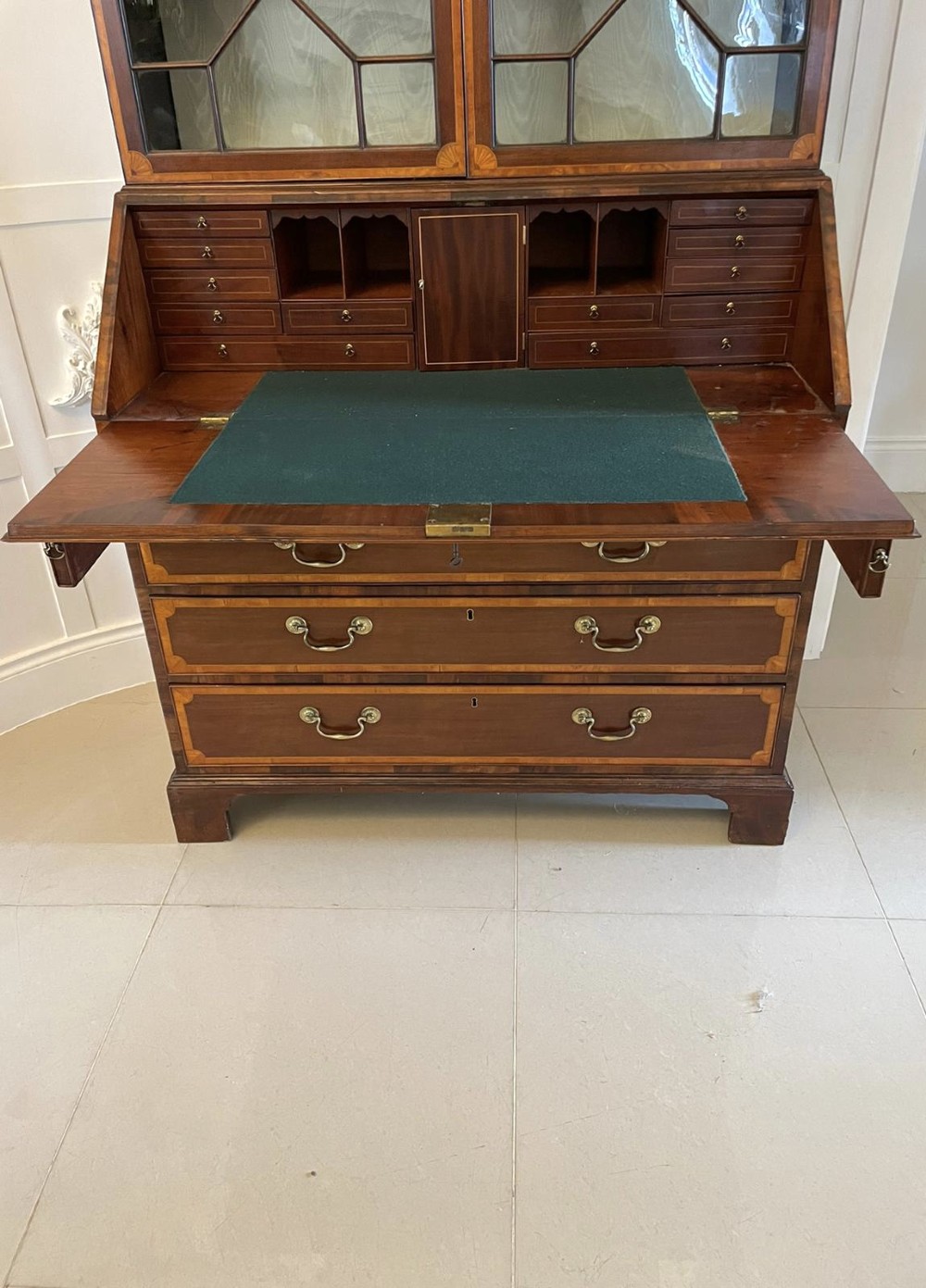 An 18th-century George III mahogany bureau bookcase featuring an upper astragal glazed cabinet above a slanted writing desk with four inlaid drawers and brass handles. View XIII