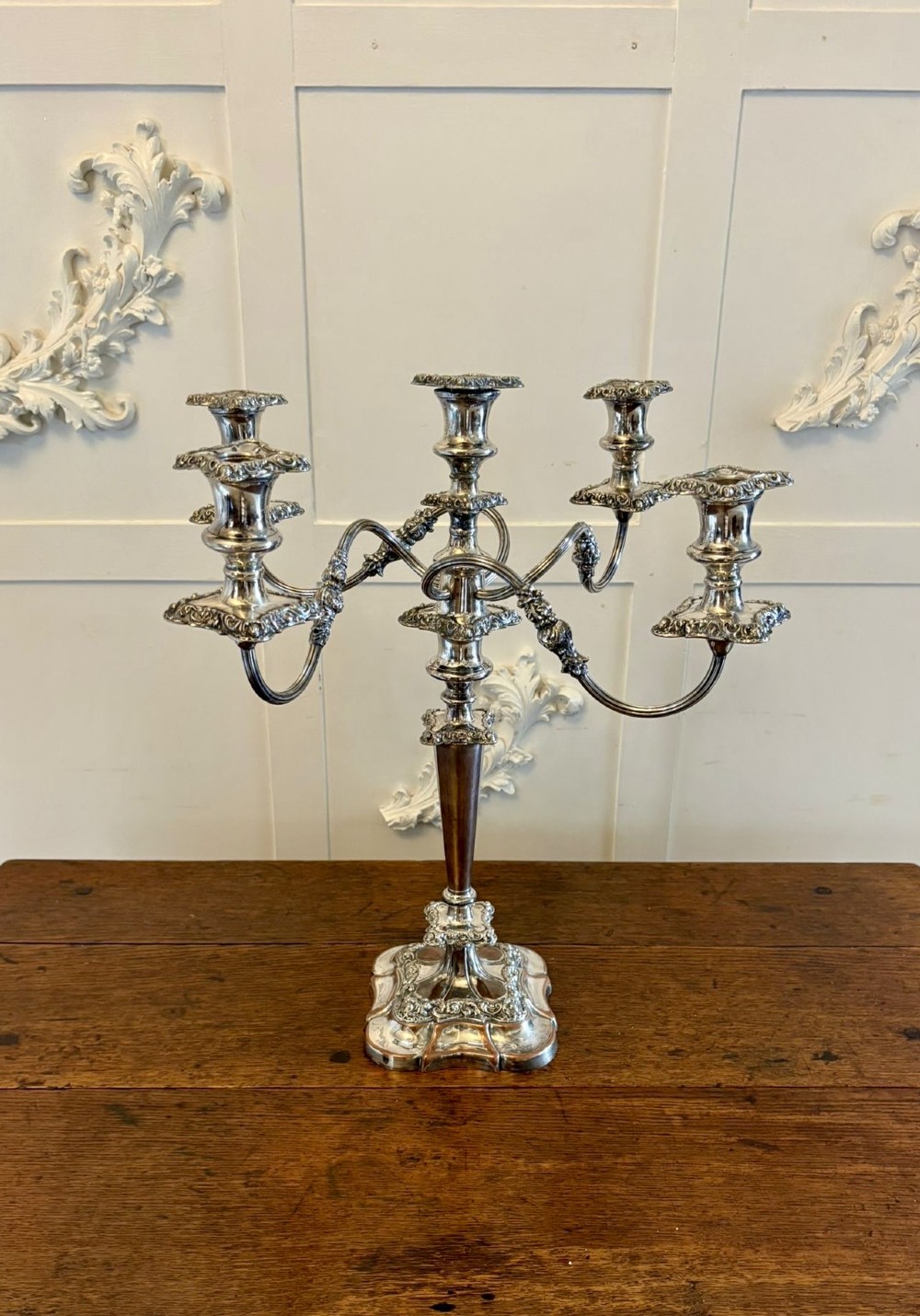 A Victorian silver-plated five-branch candelabra featuring scroll arms, ornate foliate moulding, and a shaped pedestal base.