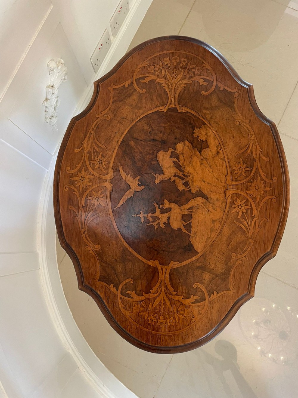 An antique walnut tilt-top side table featuring an oval top with elaborate marquetry depicting alpine wildlife and a carved tripod pedestal base. View IV