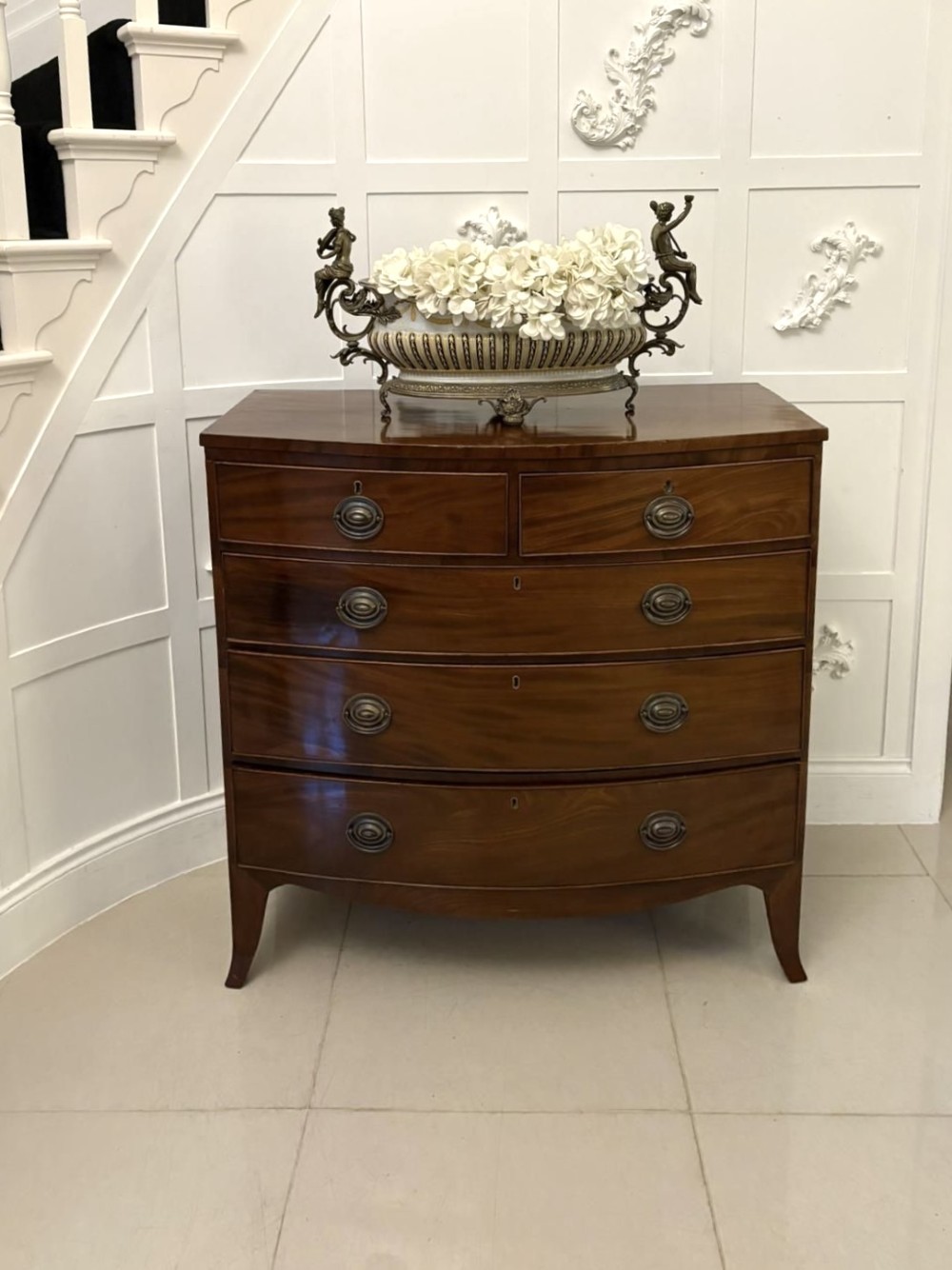 A George III mahogany bow-fronted chest featuring two short over three long graduating drawers with brass oval handles and splayed bracket feet. View VIII