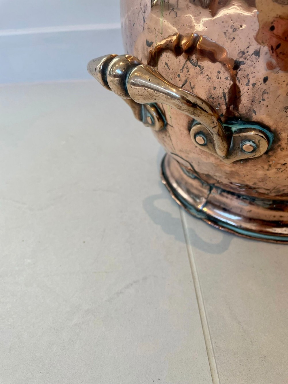 An antique George III copper helmet-shaped coal scuttle featuring an overhead swing handle, a rear loop handle, and a circular stepped pedestal base. View VII