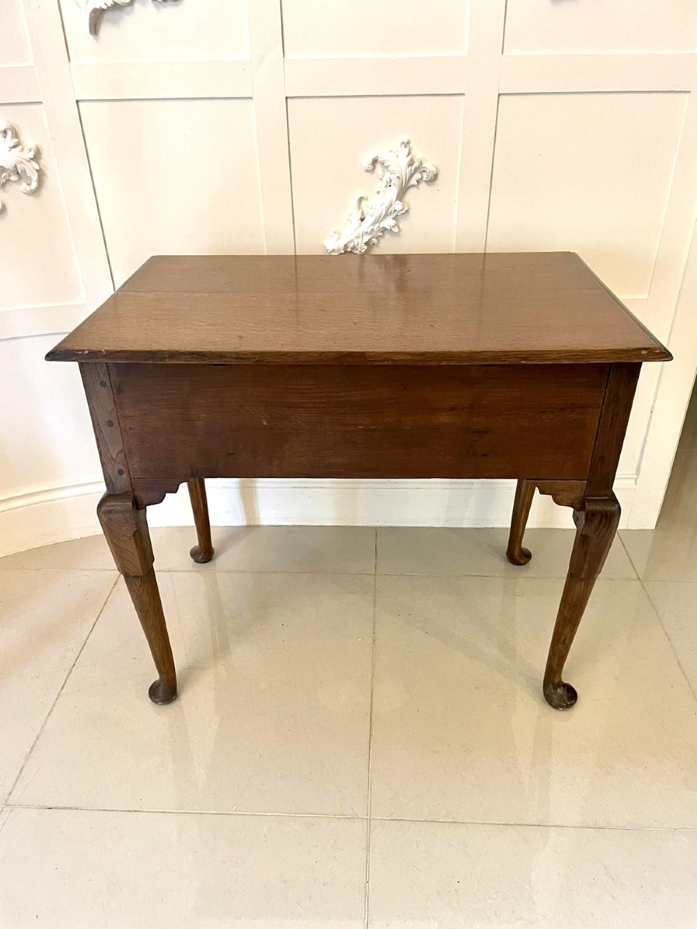 An 18th-century George III oak lowboy featuring three drawers with brass swan-neck handles, a shaped apron, and cabriole legs ending in pad feet. View II