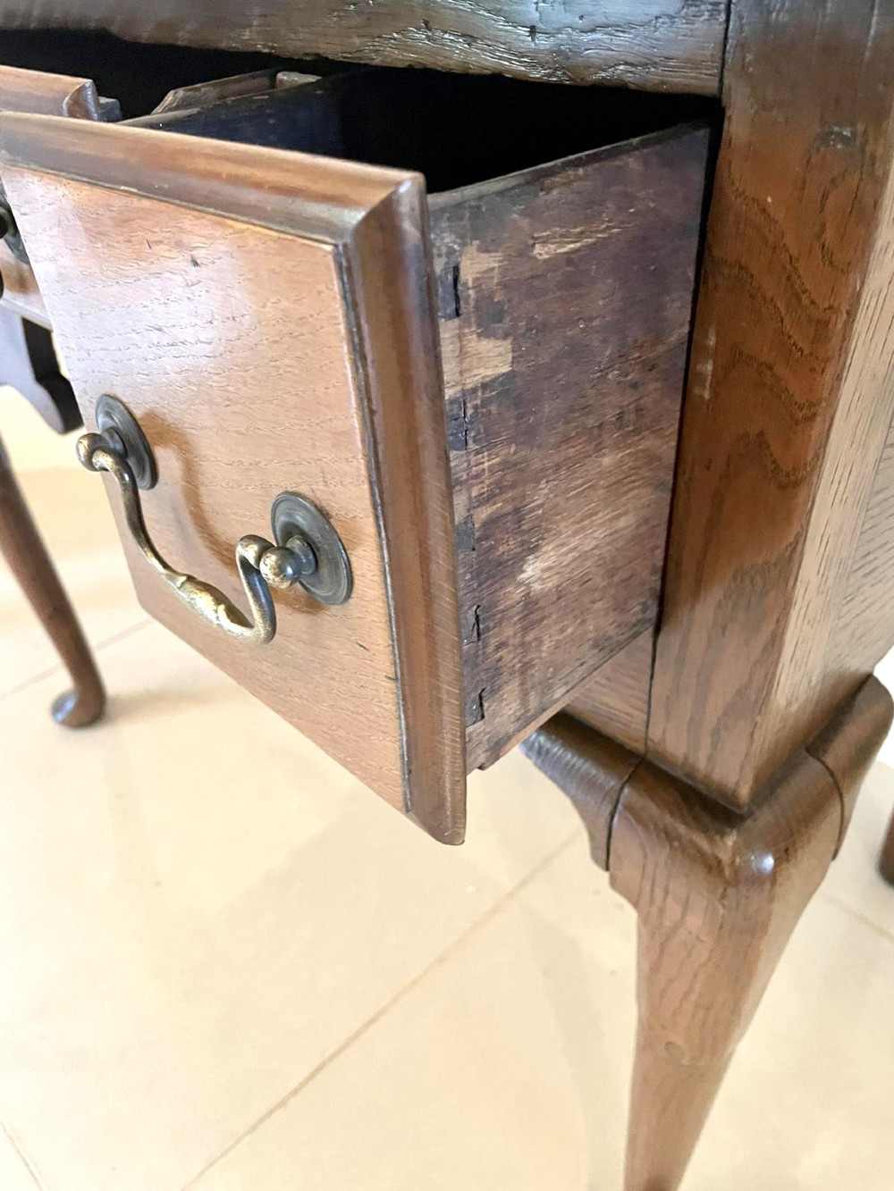An 18th-century George III oak lowboy featuring three drawers with brass swan-neck handles, a shaped apron, and cabriole legs ending in pad feet. View XI