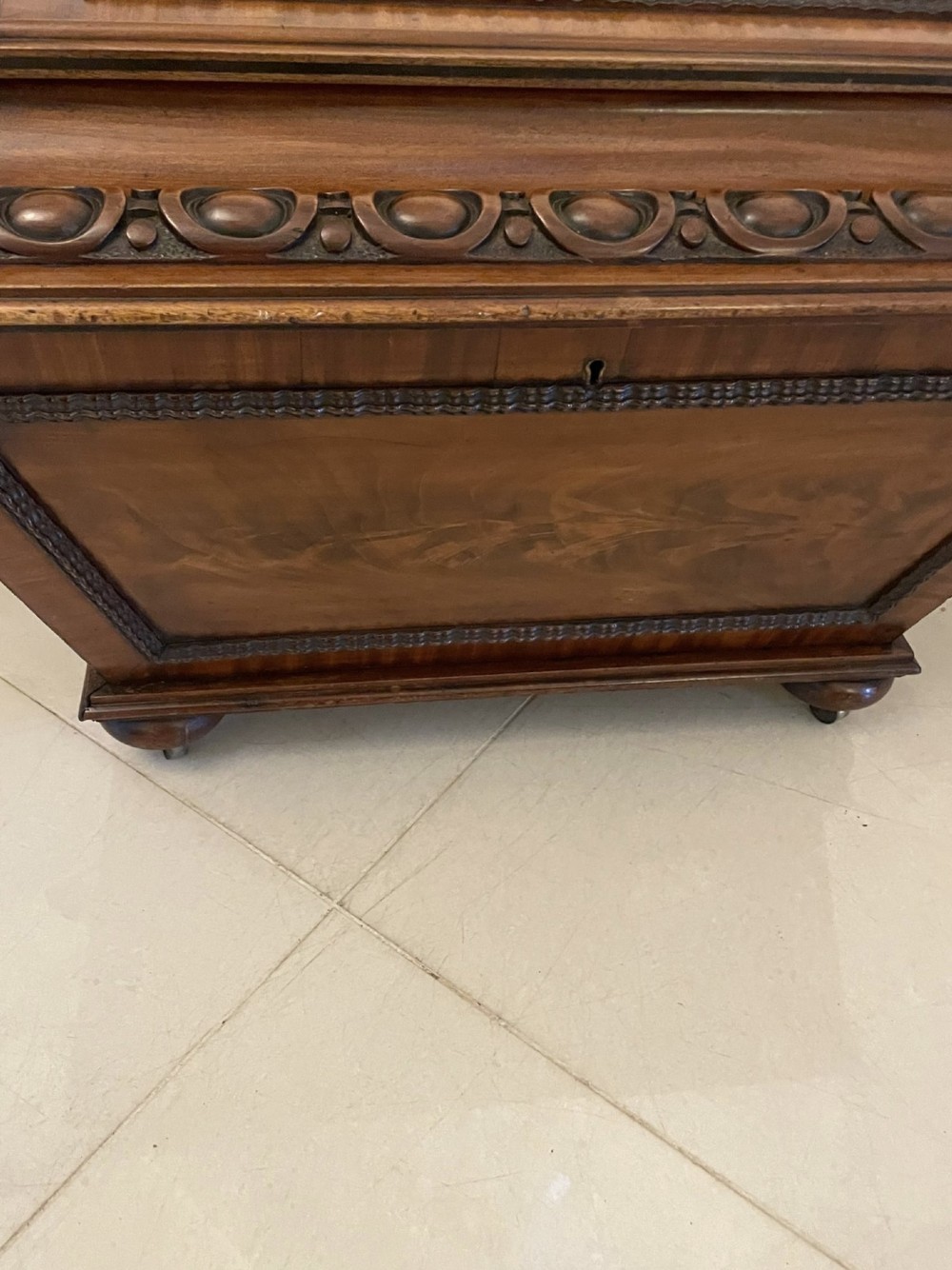 A William IV sarcophagus-shaped mahogany wine cooler featuring carved egg-and-dart moulding and a stepped lid set on short legs with castors. View VII