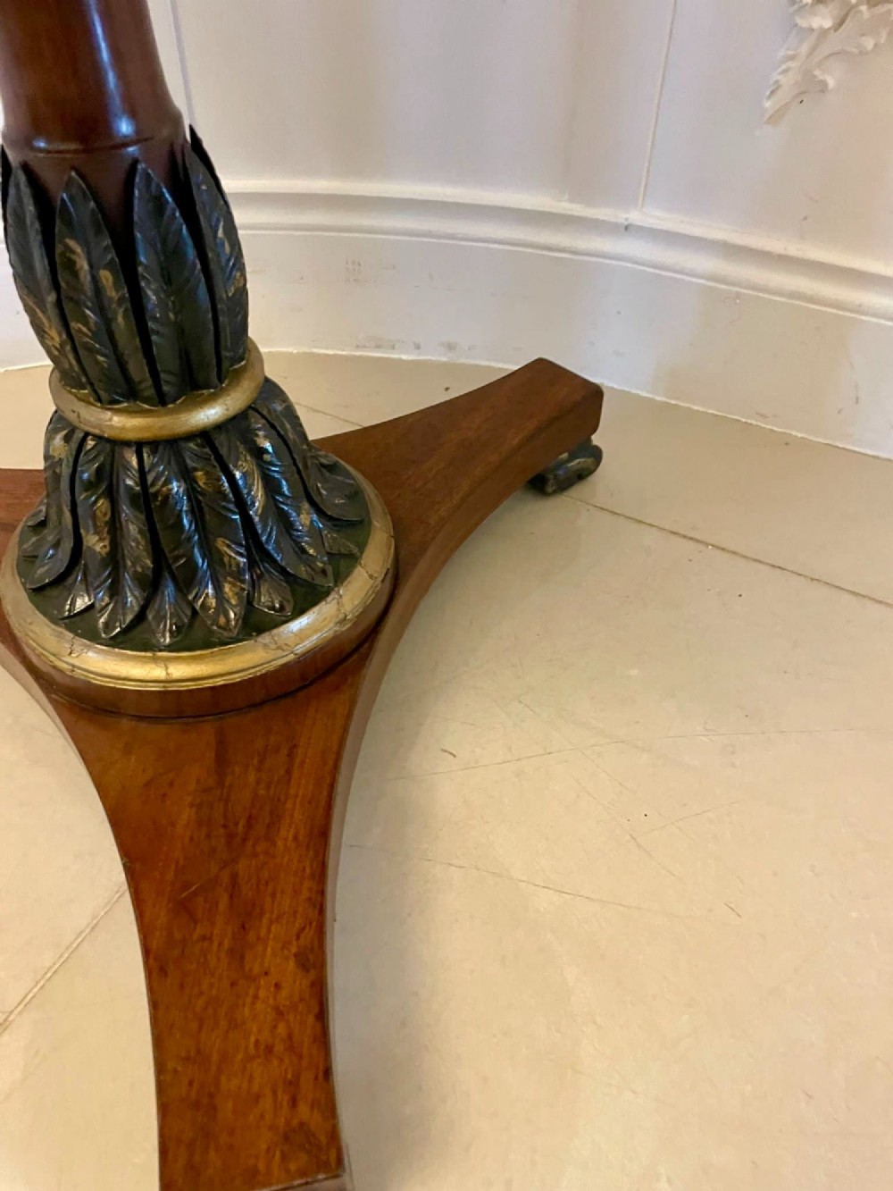 A circular Victorian centre table featuring a geometric specimen marble inlaid top resting on a dark carved mahogany pedestal with a triform base. View V