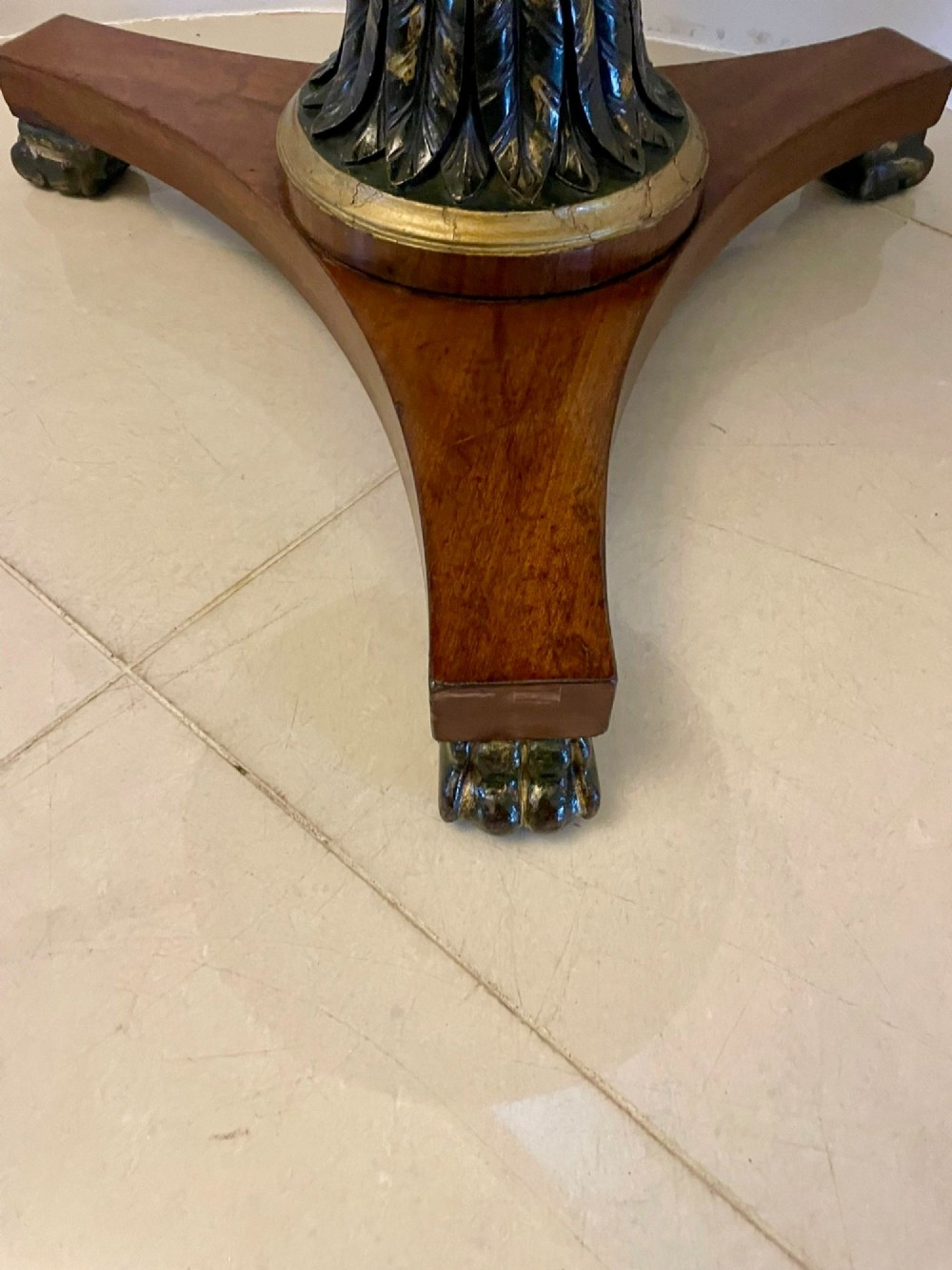 A circular Victorian centre table featuring a geometric specimen marble inlaid top resting on a dark carved mahogany pedestal with a triform base. View VI