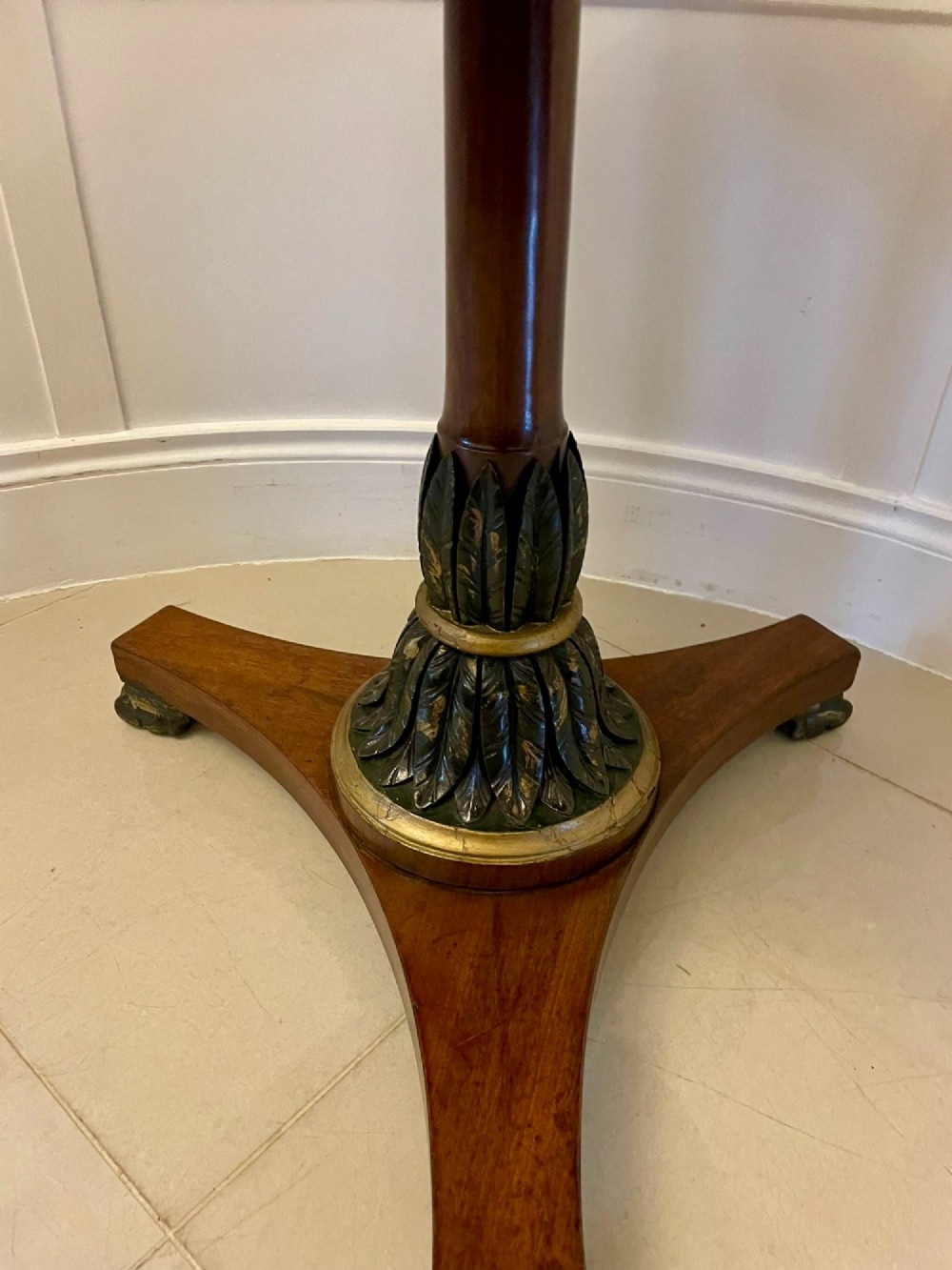 A circular Victorian centre table featuring a geometric specimen marble inlaid top resting on a dark carved mahogany pedestal with a triform base. View VII