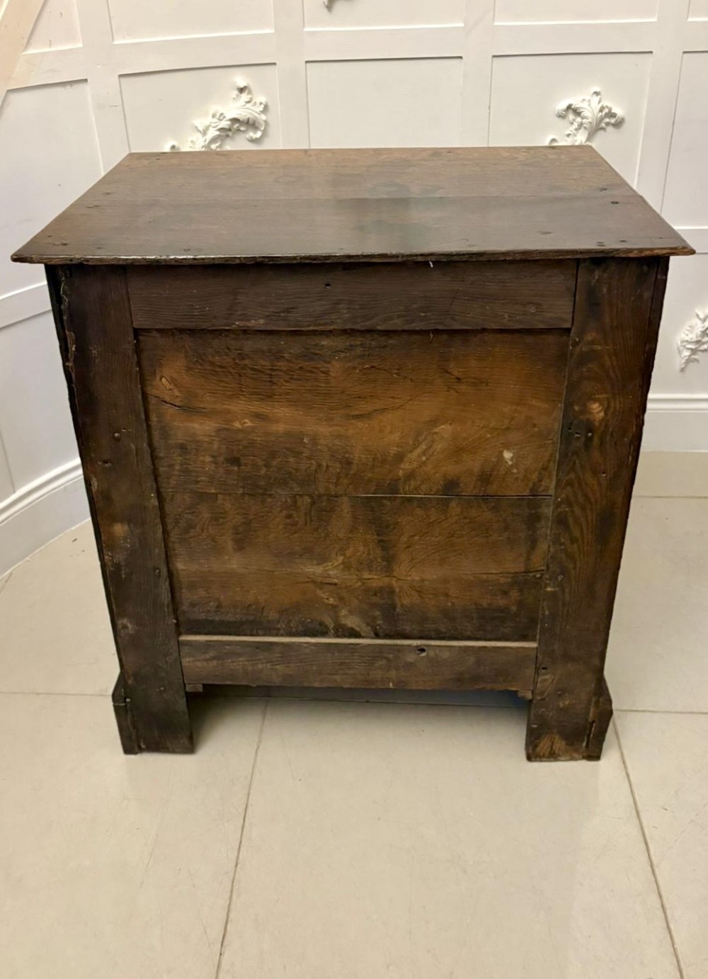 A dark oak Jacobean chest of drawers featuring geometric moulded drawer fronts and brass drop handles. View XII