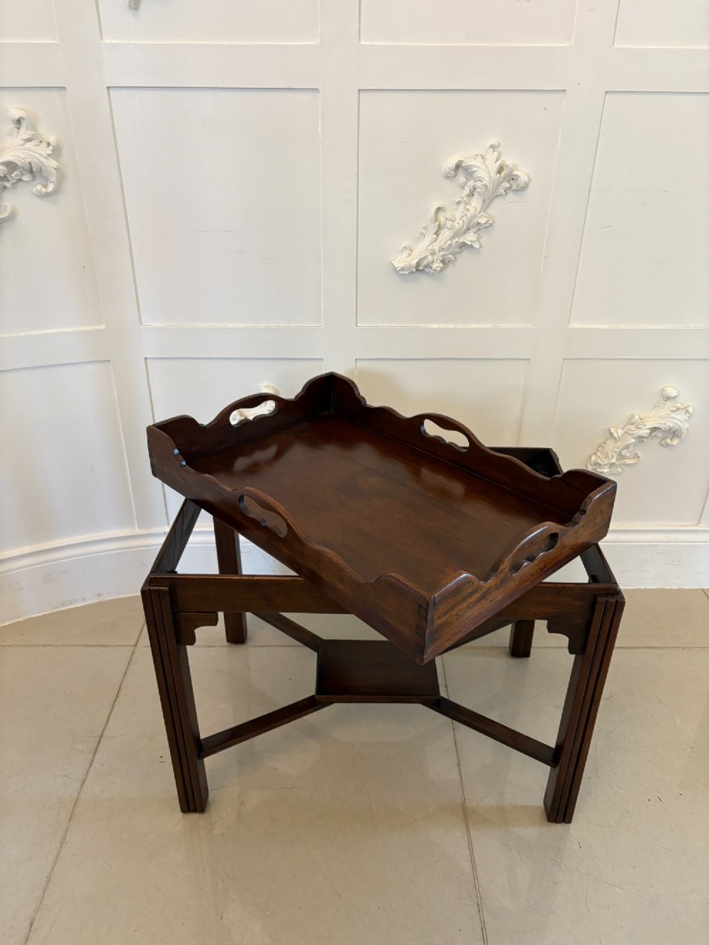 An Edwardian dark mahogany butlers tray featuring cut-out hand holes and a galleried rim, resting on a sturdy matching wooden stand with X-stretchers. View II