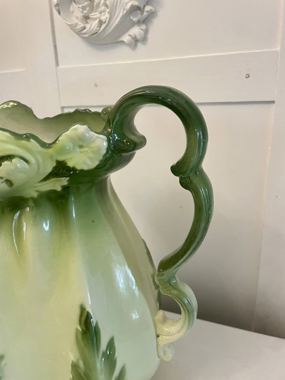 An Art Nouveau green and cream glazed ceramic jug with moulded relief leaf details resting inside a matching wash basin. View X