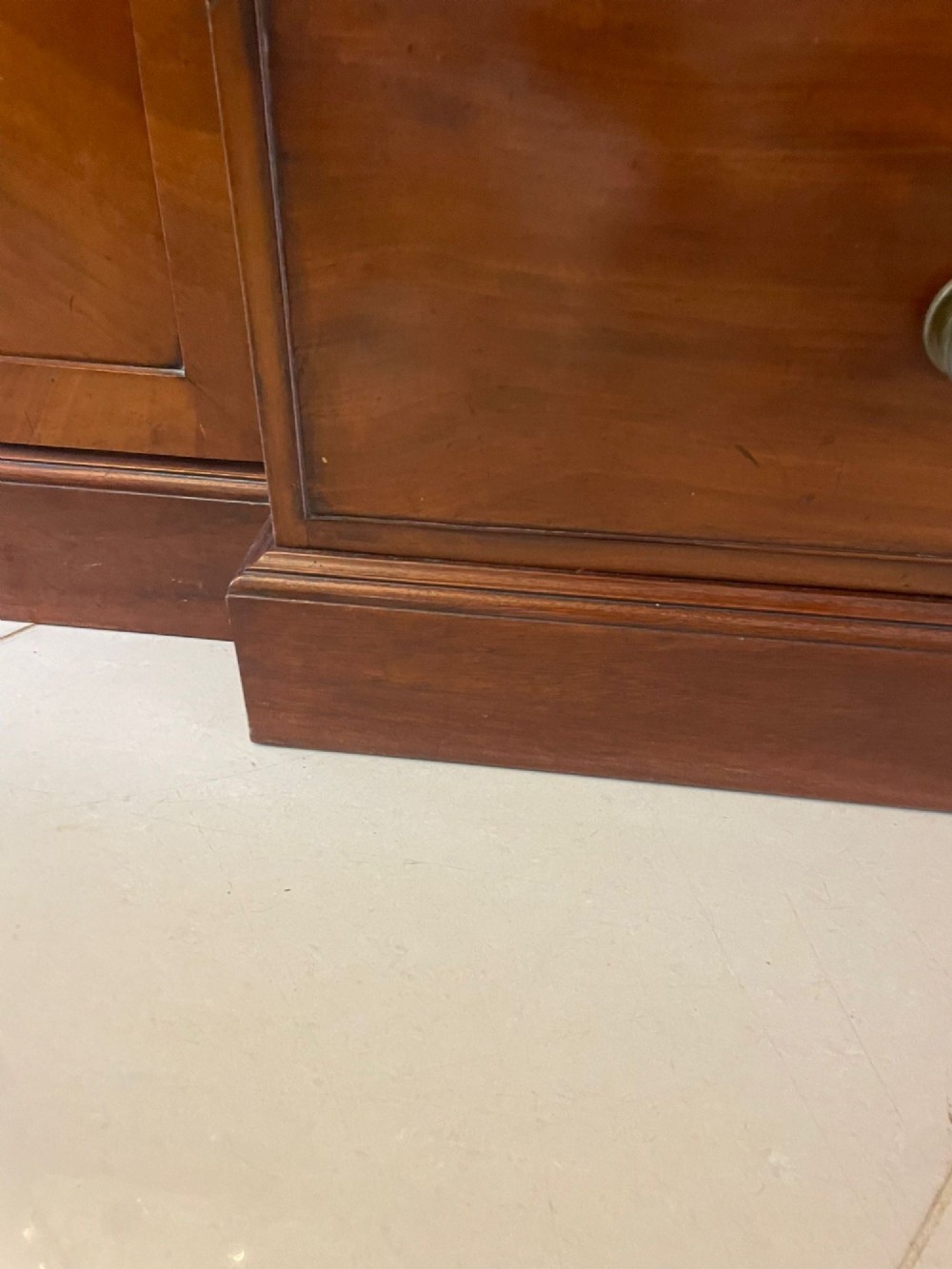 A large George III mahogany breakfront bookcase featuring a swan-neck pediment, glazed upper doors, and a lower section with drawers and cupboards. View II