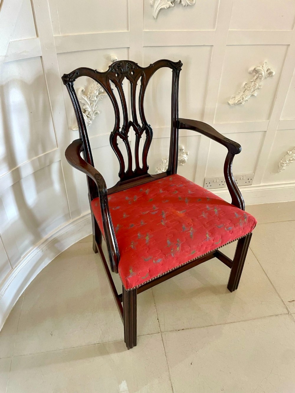 A set of twelve carved dark mahogany dining chairs featuring intricate pierced back splats and red patterned upholstered seats. View XIV