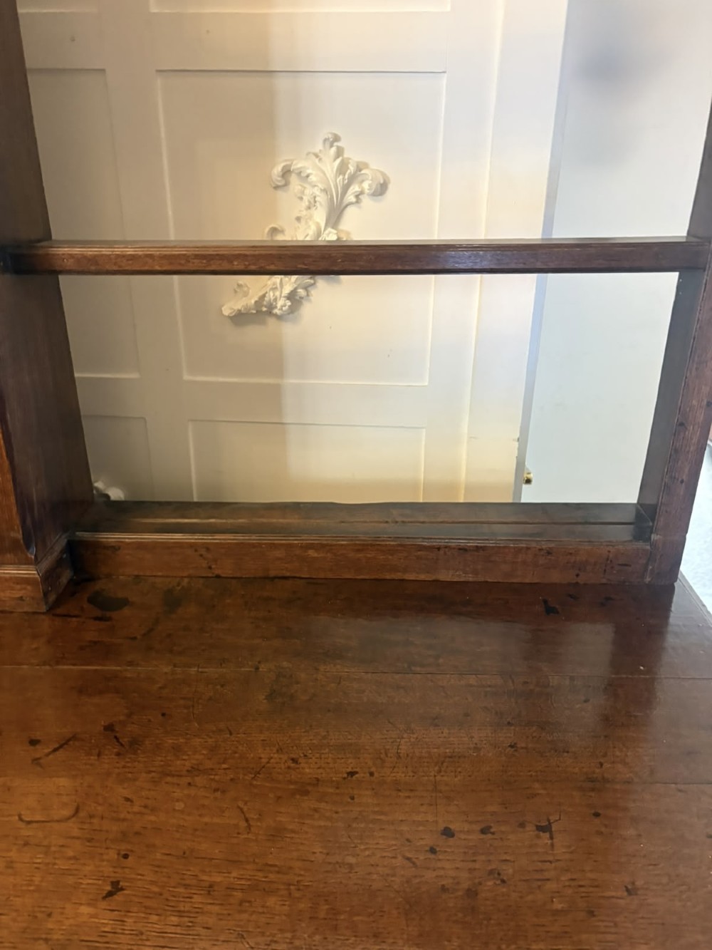 A dark oak Georgian Lancashire dresser with a scalloped open plate rack, central cupboard section, and base containing multiple drawers with brass handles. View IX