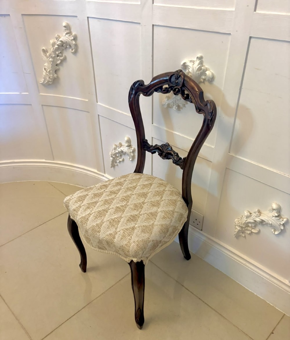 A set of four Victorian carved walnut dining chairs with open balloon-style backs and cream pattern-upholstered seats. View VIII
