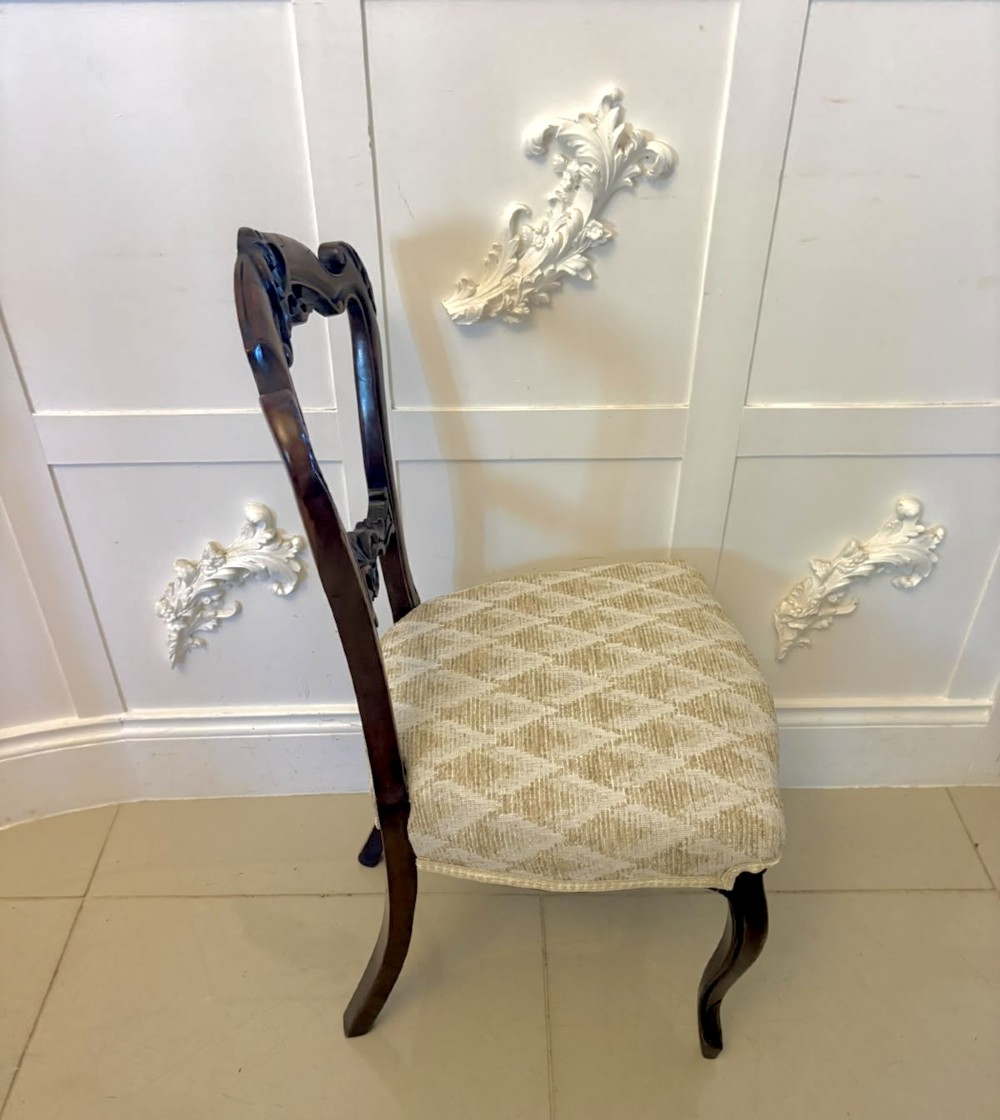 A set of four Victorian carved walnut dining chairs with open balloon-style backs and cream pattern-upholstered seats. View IX