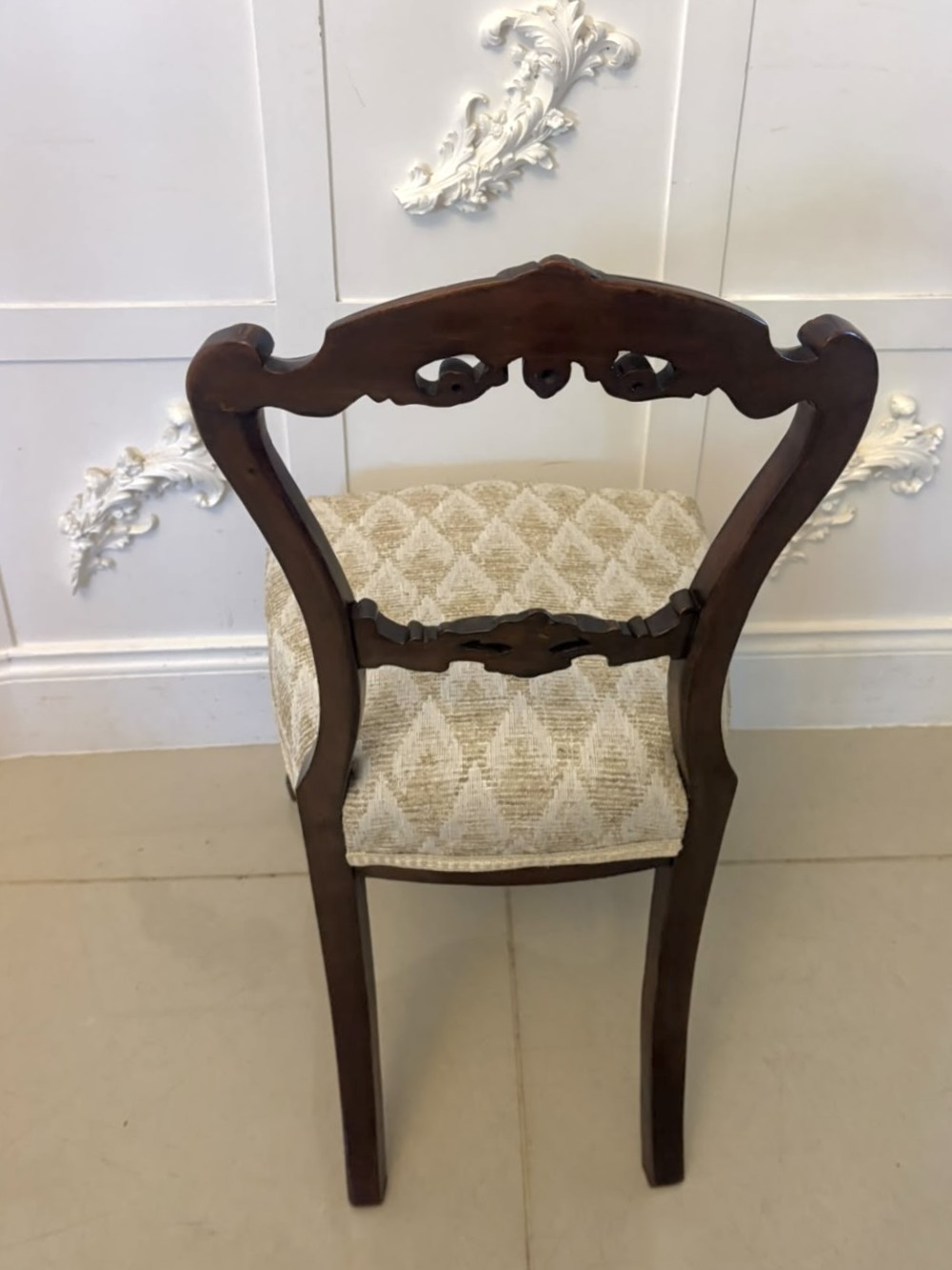 A set of four Victorian carved walnut dining chairs with open balloon-style backs and cream pattern-upholstered seats. View XII