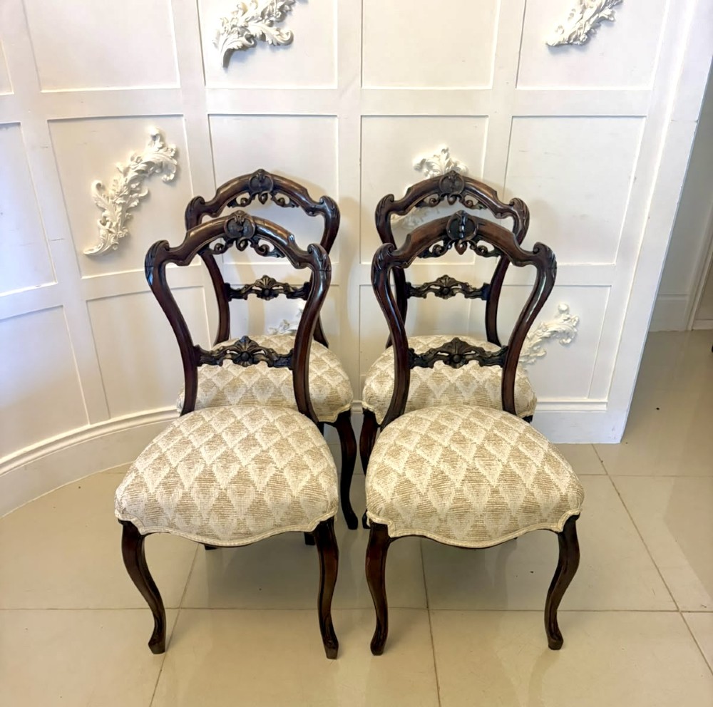 A set of four Victorian carved walnut dining chairs with open balloon-style backs and cream pattern-upholstered seats. View XIV