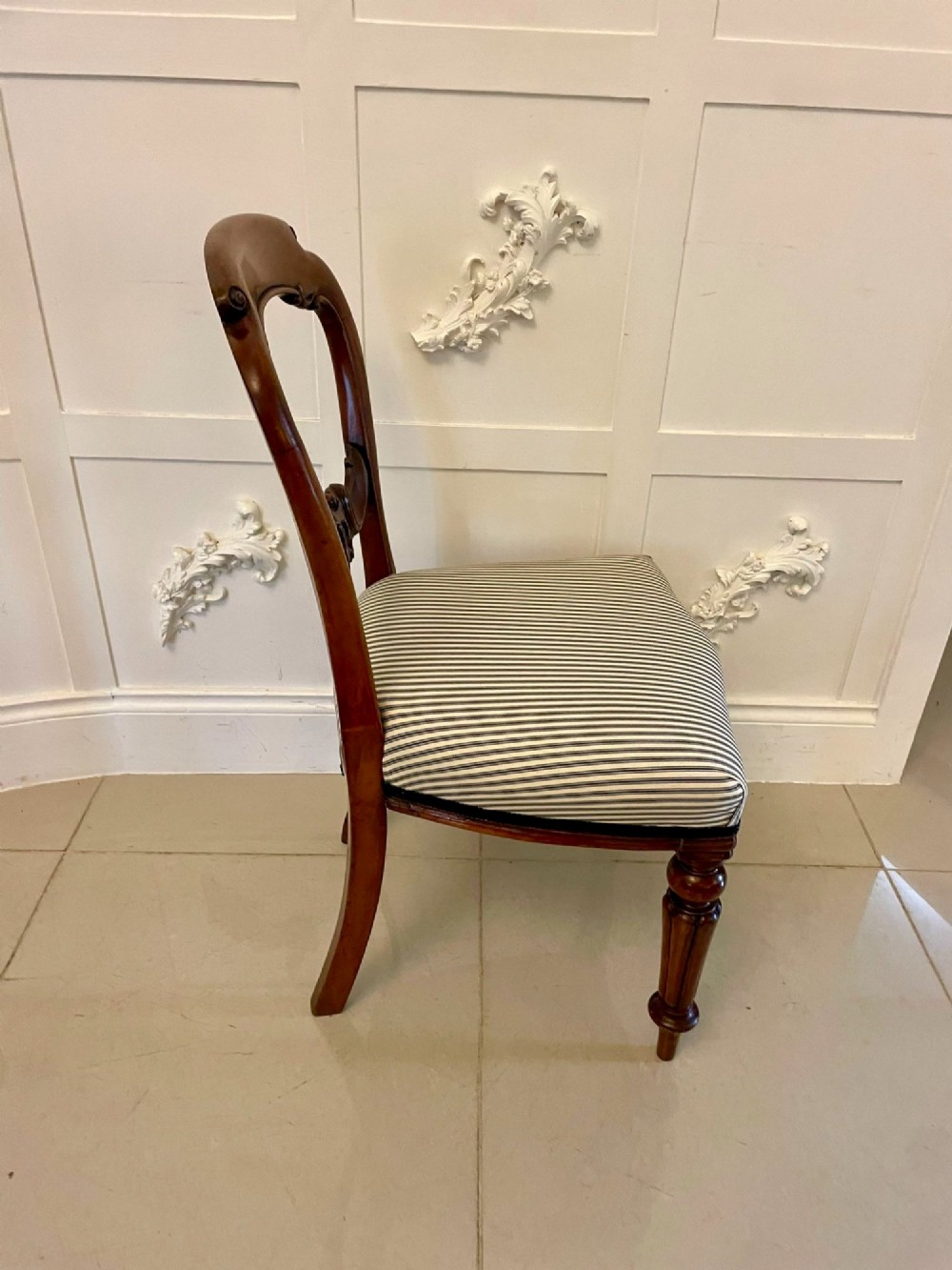 A set of six Victorian mahogany balloon back dining chairs with carved waist rails, turned front legs, and striped upholstered seats. View II