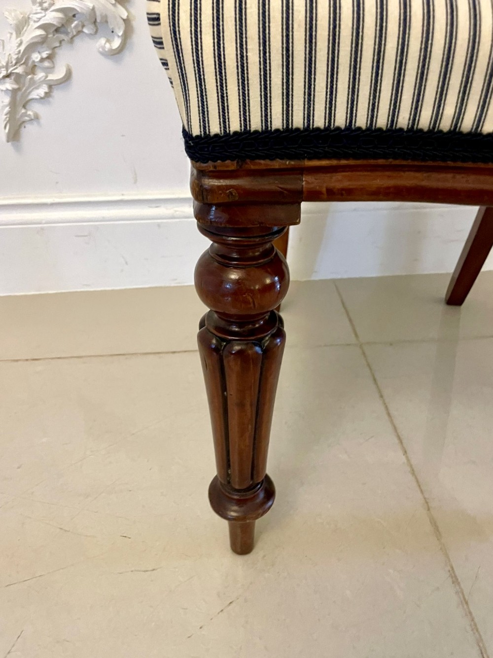A set of six Victorian mahogany balloon back dining chairs with carved waist rails, turned front legs, and striped upholstered seats. View V