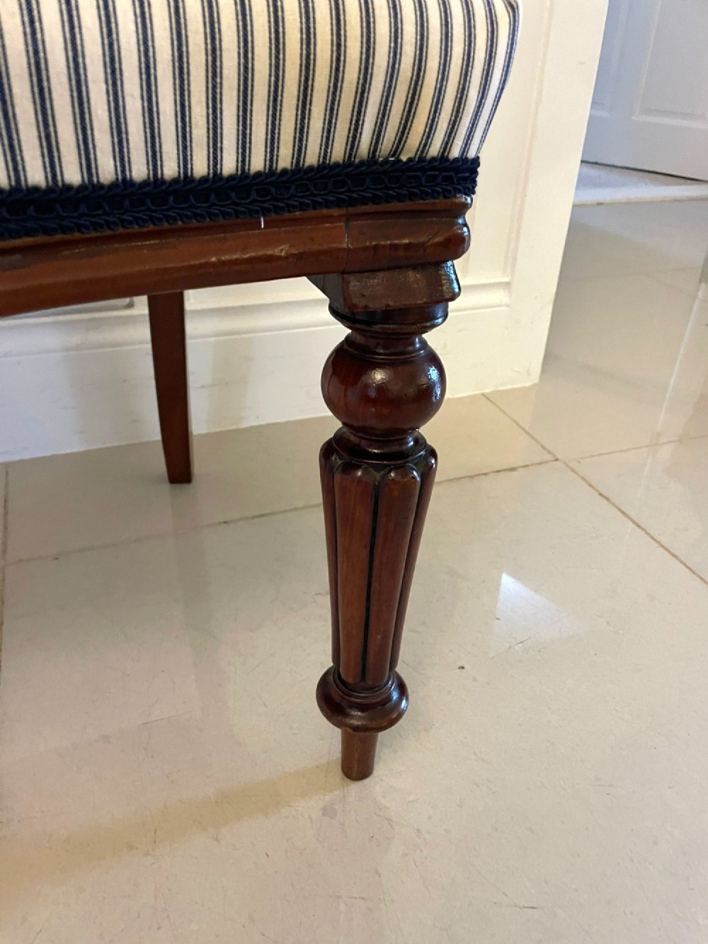A set of six Victorian mahogany balloon back dining chairs with carved waist rails, turned front legs, and striped upholstered seats. View VI