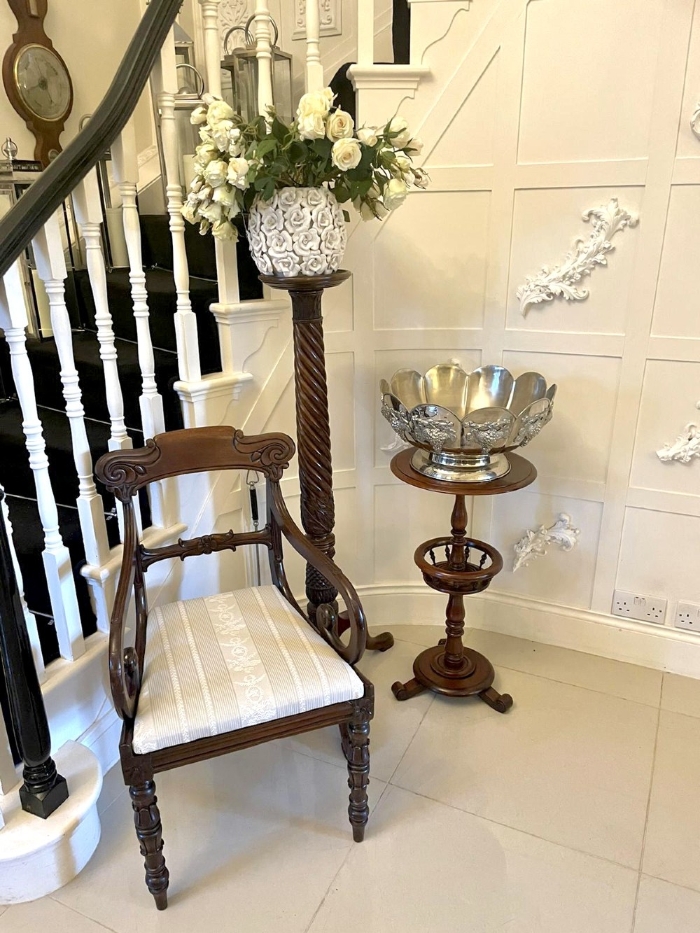 An antique Victorian circular mahogany lamp table featuring a central turned stem with an integrated balustrade mid-tier gallery, resting on a tripod base with scroll feet. View V