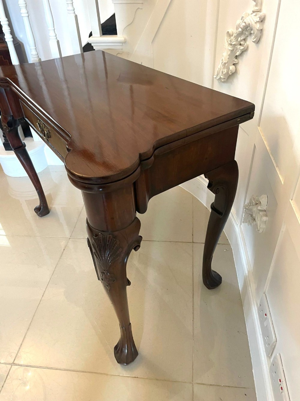 An 18th-century George II mahogany fold-over card table with carved cabriole legs, shell knees, and a central frieze drawer. View IX