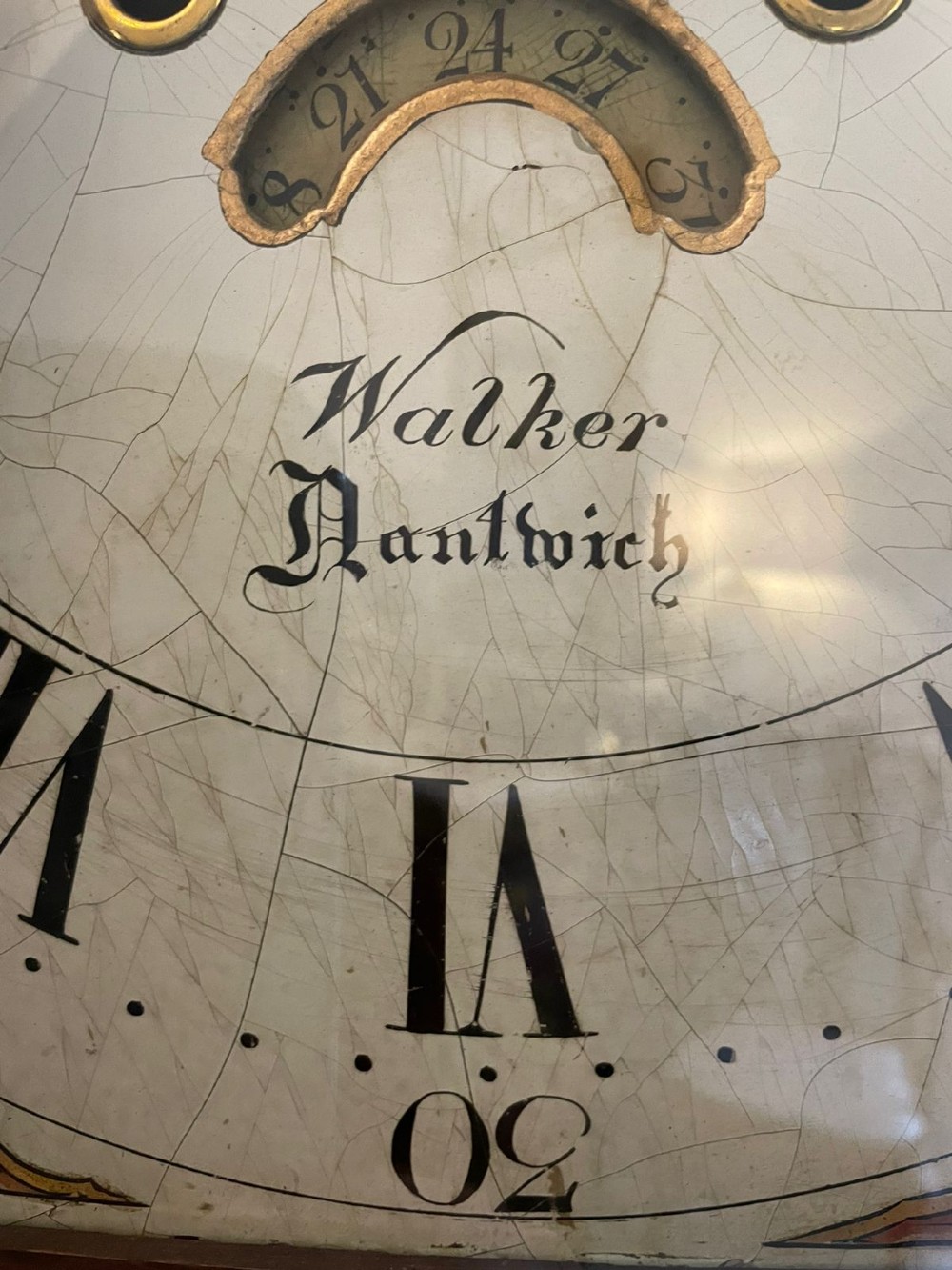 An antique George III oak longcase clock featuring a swan-neck pediment, brass fittings, and a painted arch dial with Roman numerals. View VIII