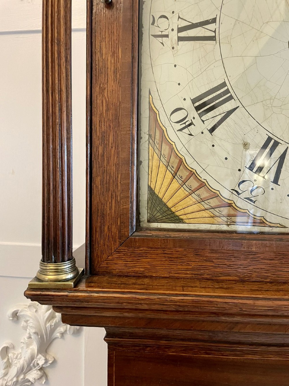An antique George III oak longcase clock featuring a swan-neck pediment, brass fittings, and a painted arch dial with Roman numerals. View IX