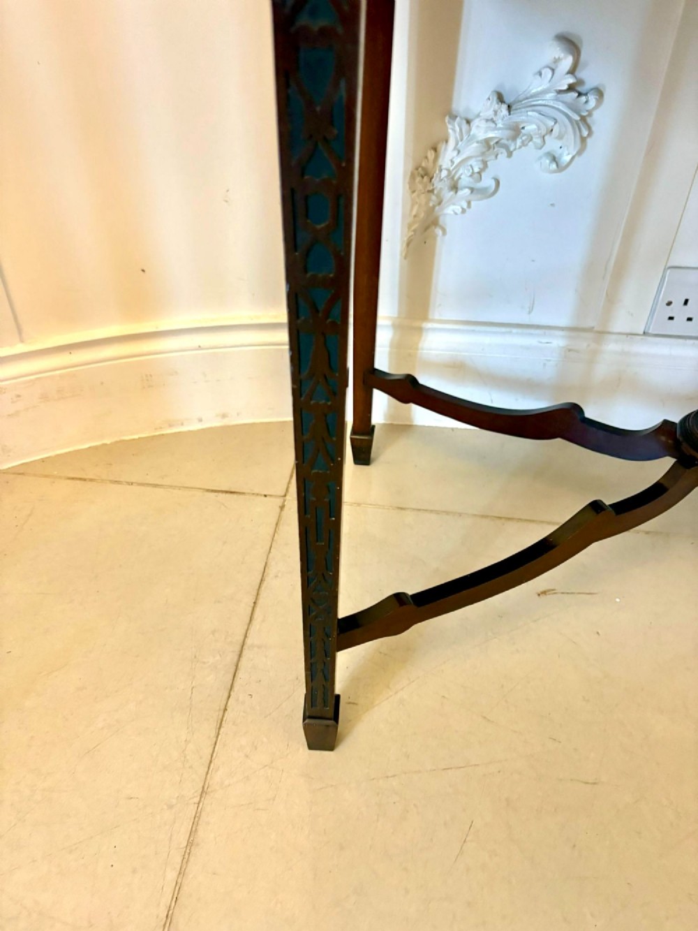 A carved mahogany bijouterie display cabinet featuring openwork fretwork pediment, glazed upper doors, and a glass-topped lower display compartment supported by slender legs with an X-shaped stretcher. View IX