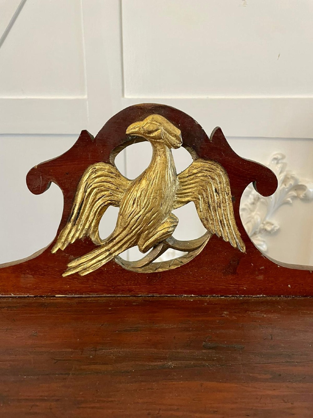 A dark wood Victorian desktop chest of eight shallow drawers featuring carved gilt lettering and a carved phoenix crest on the pediment. View III