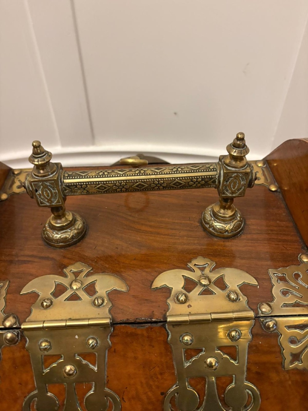 A Victorian walnut coal purdonium featuring ornate decorative brass strap hinges, brass corner plates, and a top carrying handle. View VII