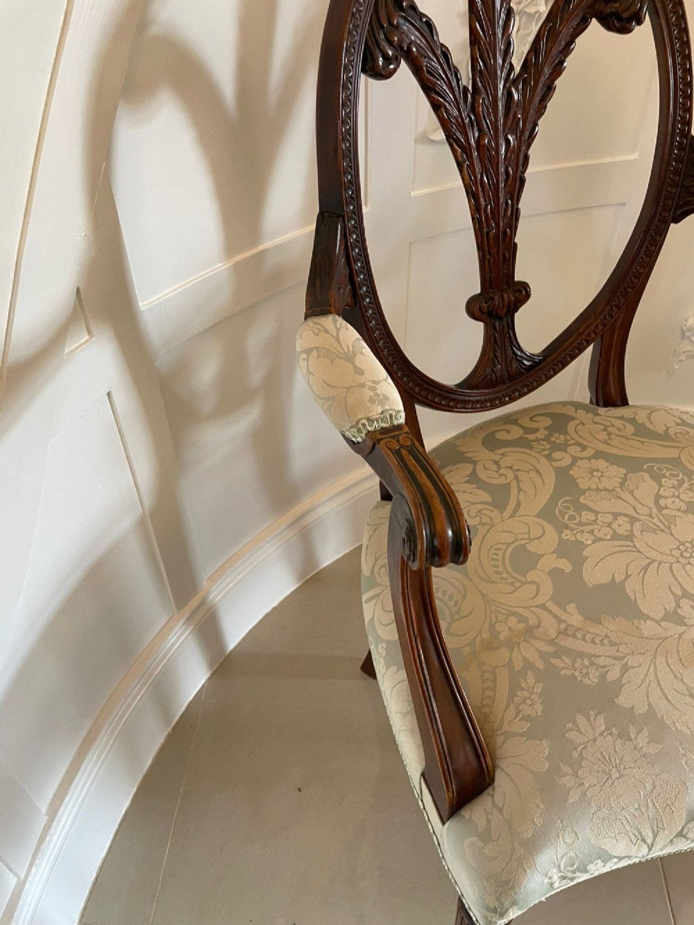 A pair of carved mahogany open armchairs featuring oval backs with carved splats, padded armrests, and pale green patterned fabric seats on fluted front legs. View VIII